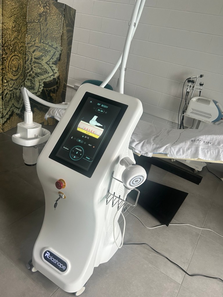RolaShape body contouring machine with touchscreen display in a clinic treatment room